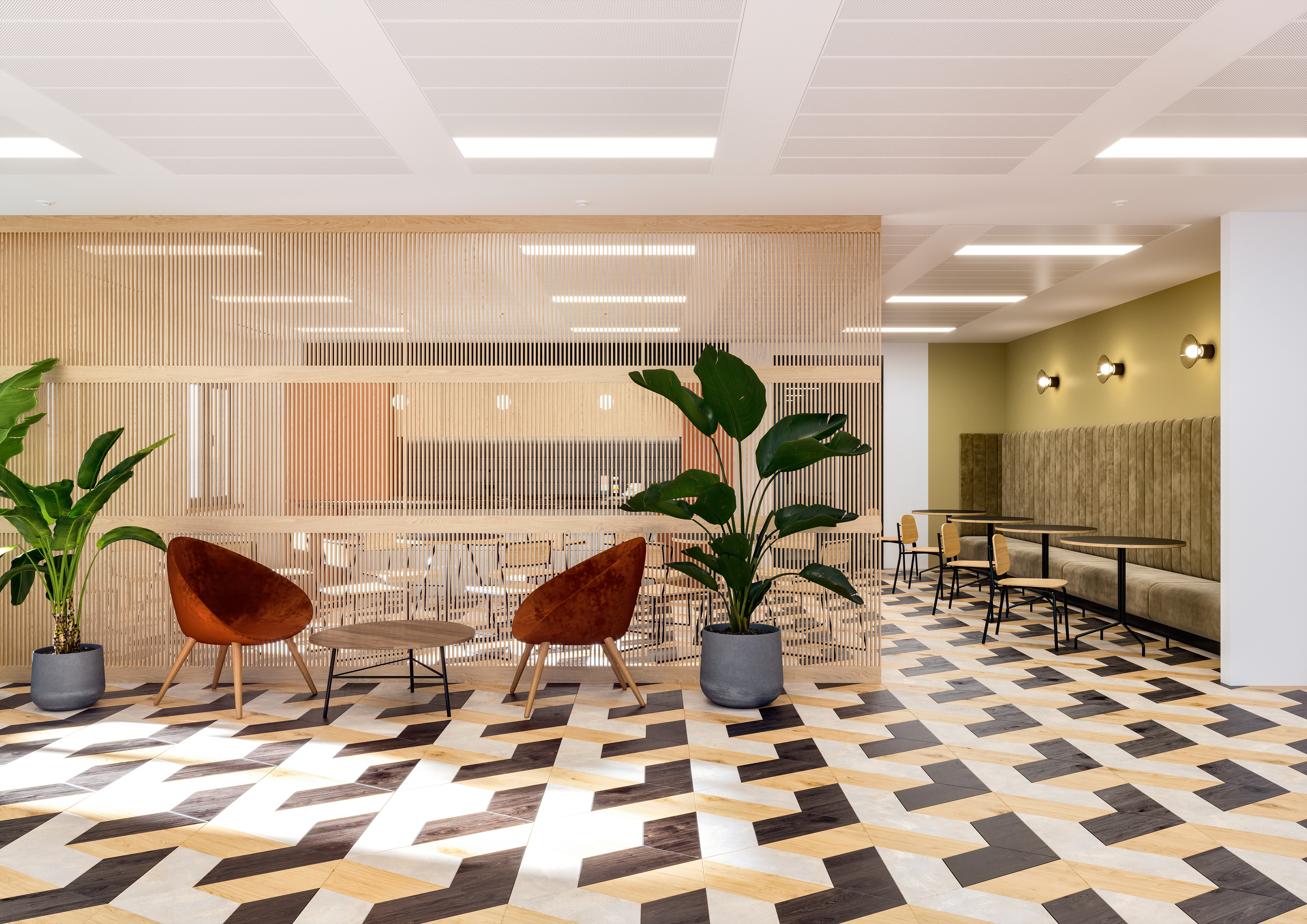 Bright breakout area featuring geometric patterned flooring, warm-toned chairs, and lush greenery, creating a vibrant and welcoming atmosphere.