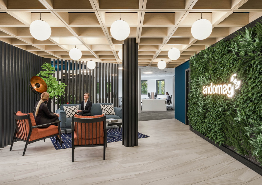 Architectural visualization of a reception lounge with vertical greenery wall and branded signage, combining hospitality elements within office design.