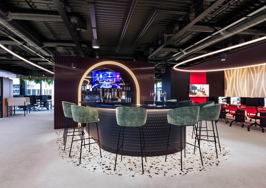 Visualization of an office bar area featuring an illuminated arch, terrazzo flooring, and green upholstered bar stools.