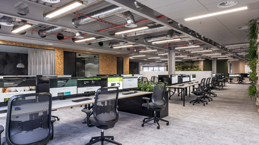 3D render of workspace with ergonomic office chairs, green dividers, and ceiling piping.