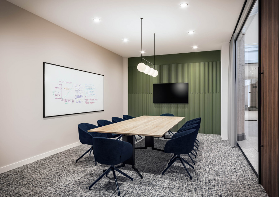 Meeting room — Visualization of a meeting space with soft hues, a green feature wall, and contemporary pendant lighting for a calm, professional atmosphere.